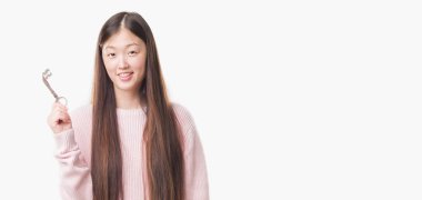 Genç gerçek durum Aracısı kadın yüzünden arka plan ayakta ve ile bir emin gülümseme gösteren gülümseyen mutlu bir yüz ile vintage tuşunu basılı tutarak izole Çin