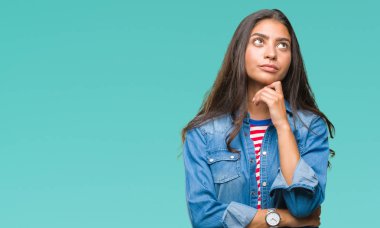 Genç güzel Arap kadın elle çene düşünme hakkında soru, dalgın ifade izole arka plan yüzünden. Düşünceli yüzüyle gülümsüyor. Şüphe kavramı.