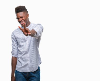 Afrikalı-Amerikalı genç zafer işareti yapıyor parmak gösterilen kamera seyir gülümseyen izole arka plan üzerinde. İki numaralı.