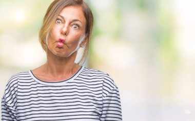 Orta yaş İspanyol kadın kıdemli izole arka plan yapma balık yüzüne dudaklı, çılgın ve komik bir jest. Komik ifade.