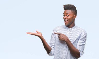 Genç Afro-Amerikan adam üzerinden hayran ve el ile sunulması ve parmak ile işaret ederken kameraya gülümseyen izole arka plan.