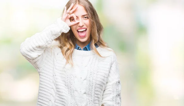 手の笑顔 幸せそうな顔で指を通して見る目で のジェスチャーを行う分離の背景に冬のセーターを着ている美しい若いブロンドの女性 — ストック写真