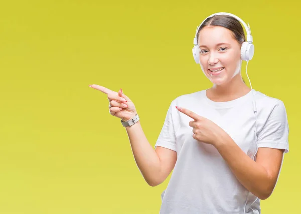 Joven Mujer Caucásica Escuchando Música Usando Auriculares Sobre Fondo Aislado —  Fotos de Stock