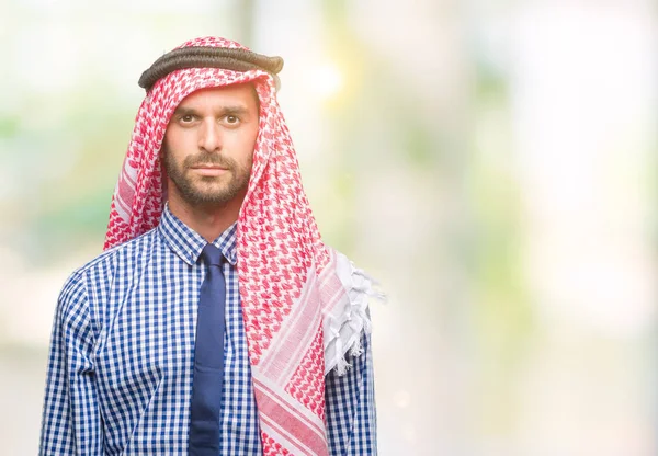 年轻英俊的阿拉伯商人穿着 Keffiyeh 在孤立的背景下 脸上表情严肃 简单而自然地看着相机 — 图库照片