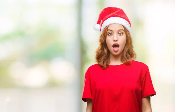 驚きの表現 恐怖と興奮した顔でショックを受けたクリスマスの帽子をかぶっている孤立した背景に若くてきれいな女性 — ストック写真
