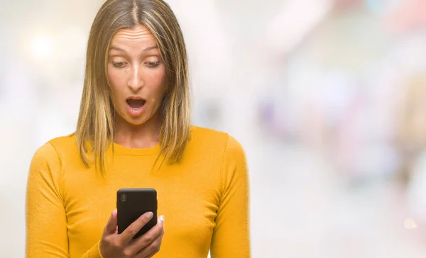 年轻美丽的女人发送消息使用智能手机在孤立的背景下吓坏了惊讶的脸 害怕和兴奋与恐惧的表情 — 图库照片