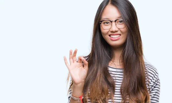 若いアジアの女性は 孤立した背景を浮かべて手と指で サインをしている肯定的な上メガネを着用します 成功した式 — ストック写真