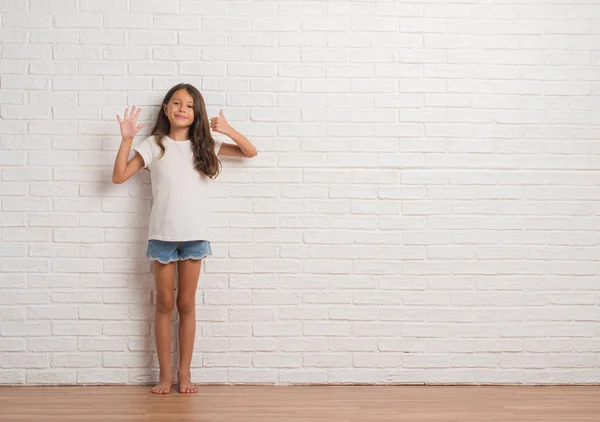 Junge Hispanische Kind Stakst Über Weiße Backsteinmauer Zeigt Und Zeigt — Stockfoto