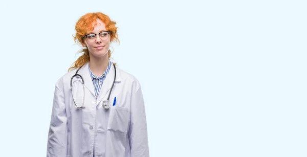 Junge Rothaarige Frau Doktoruniform Lächelt Seite Seite Und Starrt Denken — Stockfoto