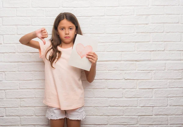 怒った顔と母の日カード 不承諾と負の符号を示す嫌悪感 拒絶反応概念を与える白いレンガの壁にヒスパニック系の子供 — ストック写真