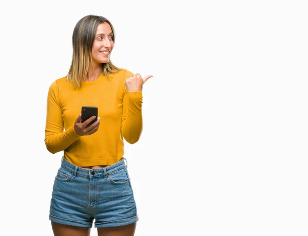 年轻的美丽的女人发送消息使用智能手机在孤立的背景指向和显示与拇指面带笑脸微笑 — 图库照片