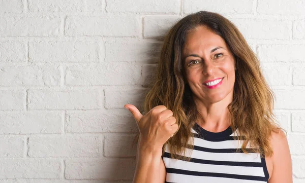 Middle Age Hispanic Woman White Brick Wall Pointing Showing Thumb — Stock Photo, Image