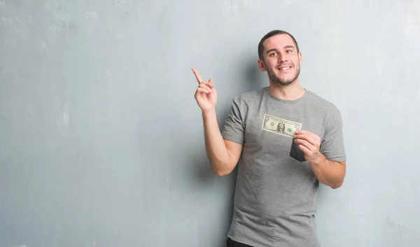 Young Caucasian Man Grey Grunge Wall Showing One Dollar Very — Stock Photo, Image