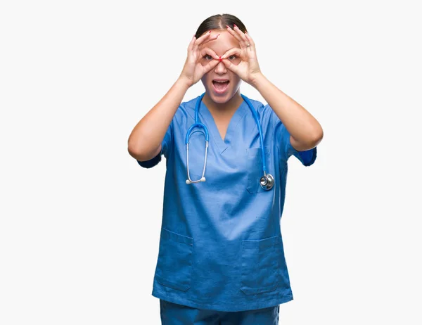 舌を出して指を通して見る目をこだわりの双眼鏡のような ジェスチャーを行う分離の背景に医療制服を着て若い白人の医者の女性 クレイジー式 — ストック写真