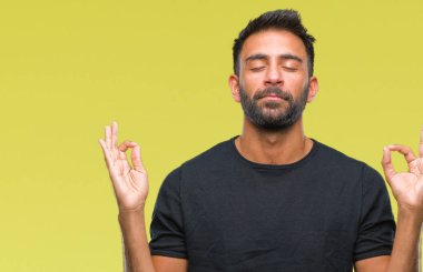 İzole arka plan yetişkin İspanyol adam rahatla ve gülümseyen gözlerle kapalı parmak jestle meditasyon yapıyor. Yoga kavramı.