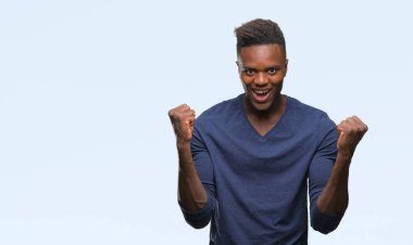 İzole arka plan kutlama üzerinde genç Afro-Amerikan adam şaşırttı ve başarı için kaldırdı kollarını açarak hayret ve gözleri açık. Kazanan kavramı.