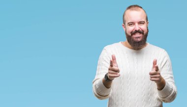 Fotoğraf makinesi ile mutlu ve komik yüz için parmakları işaret izole arka plan üzerinde kış kazak giyen genç beyaz hipster adam. İyi enerji ve vibes.