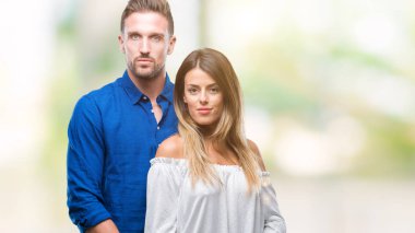 Yüzünde ciddi bir ifade ile izole arka plan üzerinde aşık genç bir çift. Basit ve doğal kameraya bakıyor.