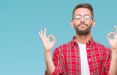 Yakışıklı delikanlı izole arka plan üzerinde dinlenmek ve gülümseyen gözlerle parmak ile meditasyon jest yapıyor kapalı. Yoga kavramı.