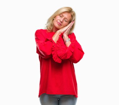 Orta yaş uyku yorgun hayal ve ellerle birlikte poz ile kapalı gözler gülümseyen izole arka plan sarışın kadın.