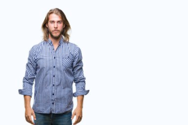 Yüzünde ciddi bir ifade ile izole arka plan üzerinde uzun saçlı Genç yakışıklı adam. Basit ve doğal kameraya bakıyor.