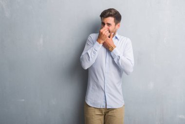 Bir şey pis ve iğrenç kokulu şık gömlek, dayanılmaz koku, holding nefes parmak ile burun üzerinde giyen gri grunge duvarın üzerinden yakışıklı genç iş adamı. Kötü kokuyor kavramı.