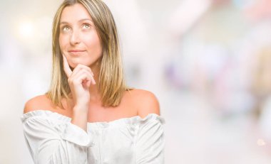 Genç güzel kadın elle çene düşünme hakkında soru, dalgın ifade izole arka plan yüzünden. Düşünceli yüzüyle gülümsüyor. Şüphe kavramı.