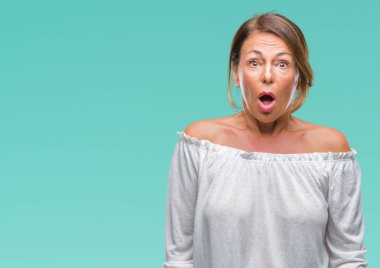 Orta yaş üst düzey İspanyol kadın izole arka plan korkuyor ve sürpriz ifade ile şok yüzünden korku ve yüz heyecanlı.