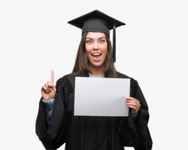 Diploma kağıt sürpriz bir fikir ya da soru işaret parmağı ile gülen yüz, bir numara tutan genç İspanyol kadın giyiyor mezun üniforma