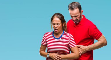 Orta yaş İspanyol çift aşık ile izole arka plan üzerinde elini karnına çünkü hazımsızlık, ağrılı hastalık hasta hissediyor. Ağrısı kavramı.