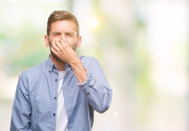 Beyaz t-shirt giyen bir şey pis ve iğrenç kokulu izole arka plan, dayanılmaz koku, holding nefes burun parmaklar ile yakışıklı delikanlı. Kötü kokuyor kavramı.