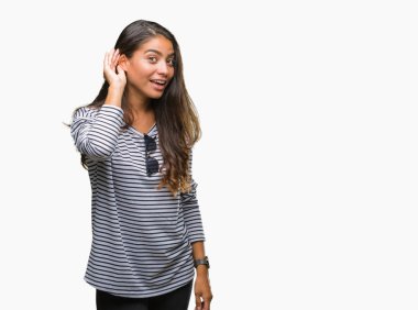 Genç güzel Arap kadın bir işitme söylenti ya da dedikodu için dinleme kulak üzerinde el ile gülümseyen izole arka plan üzerinde güneş gözlüğü takıyor. Sağırlık kavramı.