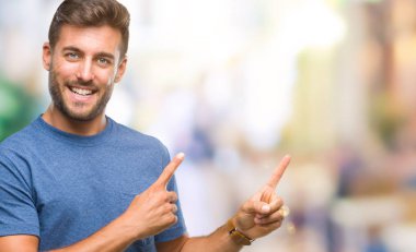 Yakışıklı delikanlı gülümseyen ve iki elleri ve parmakları ile tarafına işaret kamera bakarak izole arka plan üzerinde.