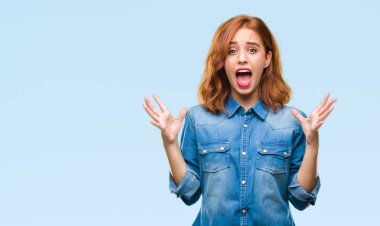 Genç güzel kadın deli kutluyor ve silah ile başarı için heyecanlı çığlık kaldırdı ve açık gözleri hayret izole arka plan yüzünden. Kazanan kavramı