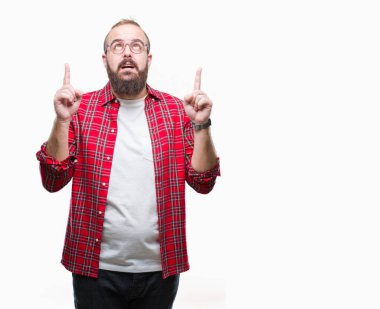 İzole arka plan üzerinde gözlüklü Genç beyaz hipster adam hayret ve yukarıya bakıp parmakları ile işaret şaşırttı ve silah kaldırdı.