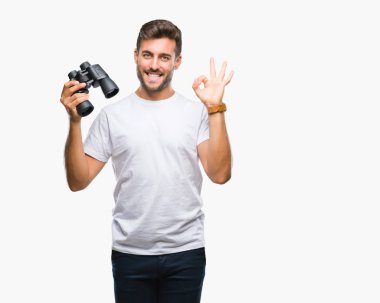 Yakışıklı delikanlı parmak, mükemmel sembolü ile ok işareti yapıyor izole arka plan üzerinde dürbün ile seyir