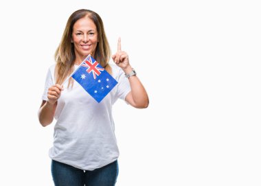 Avustralya bayrağı izole arka plan üzerinde tutan orta yaş İspanyol kadın bir fikir ya da soru işaret parmağı gülen yüz, bir numara ile şaşırttı