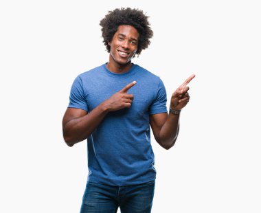 Gülümseyen ve iki elleri ve parmakları ile tarafına işaret kamera bakarak izole arka plan üzerinde Afro Amerikalı adam.