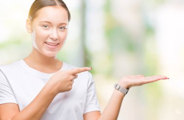 Genç güzel beyaz kadın üzerinden hayran ve el ile sunulması ve parmak ile işaret ederken kameraya gülümseyen izole arka plan.