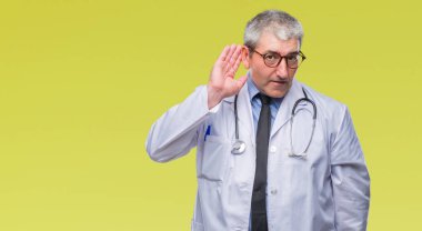 Bir işitme söylenti ya da dedikodu için dinleme kulak üzerinde el ile gülümseyen izole arka plan yakışıklı kıdemli Doktor adam. Sağırlık kavramı.