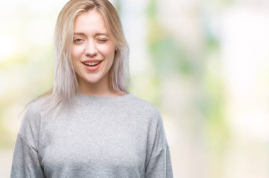 Sarışın genç kadın seksi bir ifadeyle, neşeli ve mutlu yüzünü kameraya bakarak göz kırpıyor izole arka plan üzerinde.