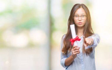 Genç Asyalı kadın holding derecesi izole arka kamera ve size parmak ile işaret üzerine, el işareti, pozitif ve kendinden emin bir jest ön