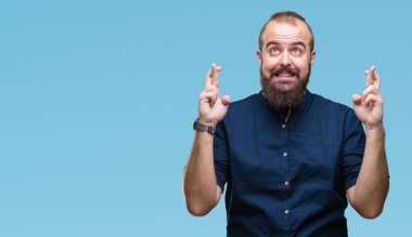 Umut ve gözleri kapalı geçiş parmaklarıyla gülümseyen izole arka plan Genç beyaz hipster adam. Şans ve batıl kavramı.