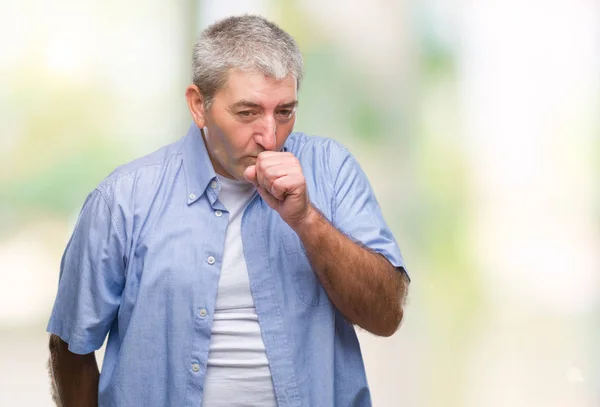 Handsome senior man over isolated background feeling unwell and coughing as symptom for cold or bronchitis. Healthcare concept.