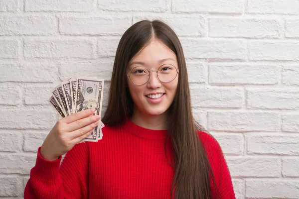 Jovem Chinesa Sobre Parede Tijolo Segurando Dólares Com Rosto Feliz — Fotografia de Stock