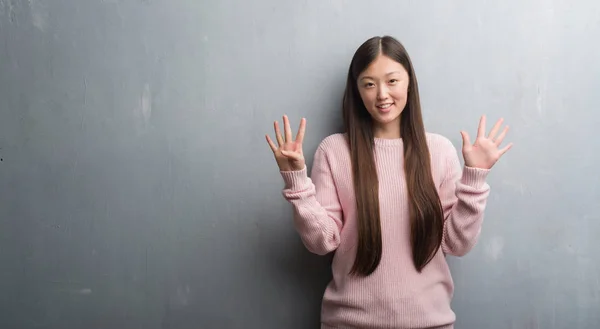 Jonge Chinese Vrouw Grijs Muur Tonen Met Vingers Omhoog Nummer — Stockfoto