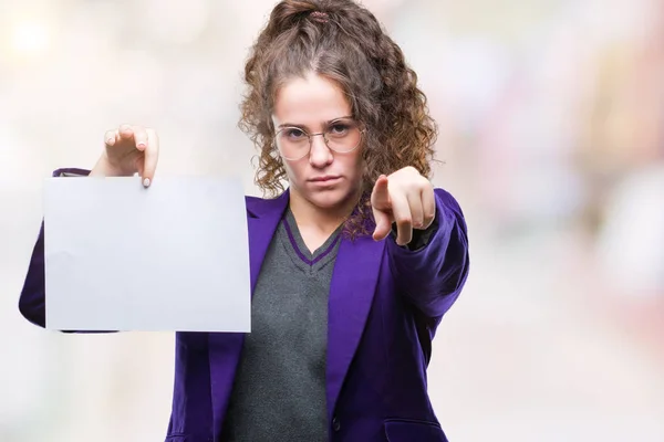 年轻的黑发学生女孩穿着校服拿着空白的纸在孤立的背景指向手指对着照相机和对你 手的标志 积极和自信的手势从前面 — 图库照片