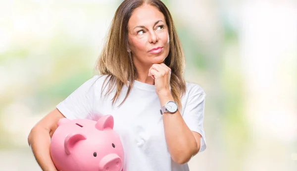 Mulher Hispânica Meia Idade Economizando Dinheiro Usando Mealheiro Sobre Fundo — Fotografia de Stock