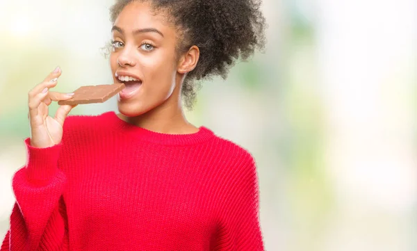 Mujer Afroamericana Joven Comiendo Barra Chocolate Sobre Fondo Aislado Con — Foto de Stock