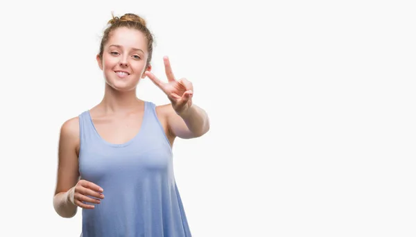 Young Blonde Woman Smiling Looking Camera Showing Fingers Doing Victory — Stock Photo, Image
